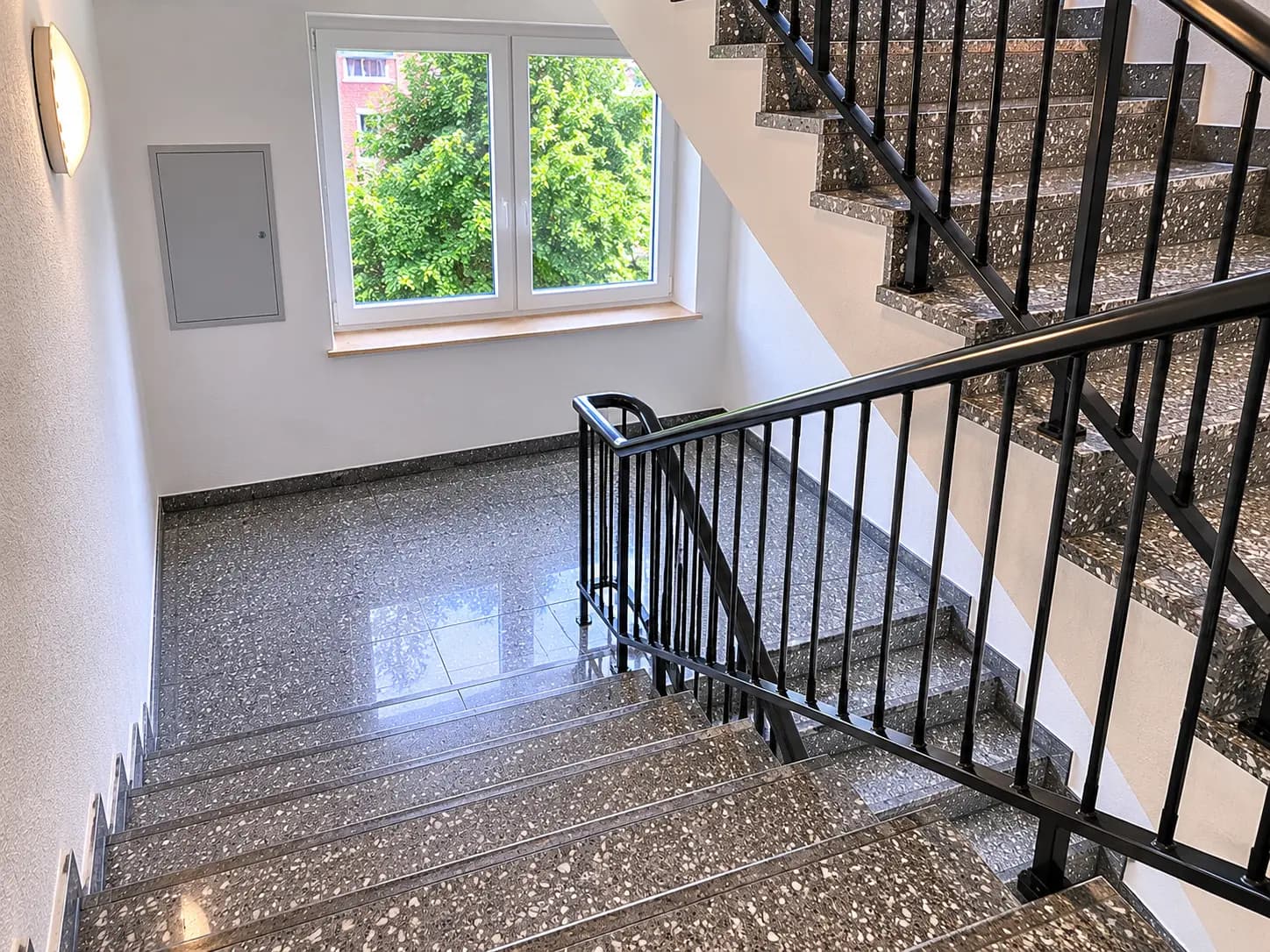 Gepflegtes Treppenhaus mit glänzendem Terrazzoboden nach professioneller Reinigung durch RH-Facility